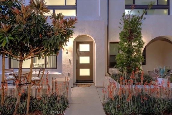 Front view of a house with a sleek door and arched entryway.