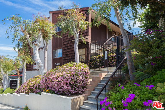 Front view of a multi-story house with wooden exterior and staircase.