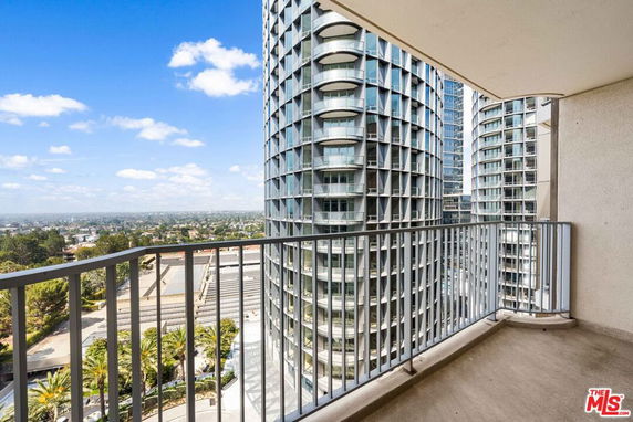 View from a balcony overlooking modern high-rise buildings and cityscape.