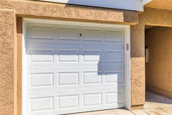 Front view of a house with a single white garage door.