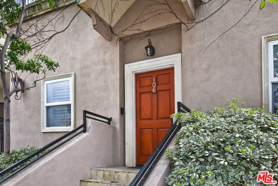 Front view of a building entrance with steps and a wooden door.