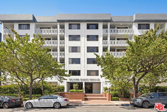 Front view of a multi-story apartment building with balconies.