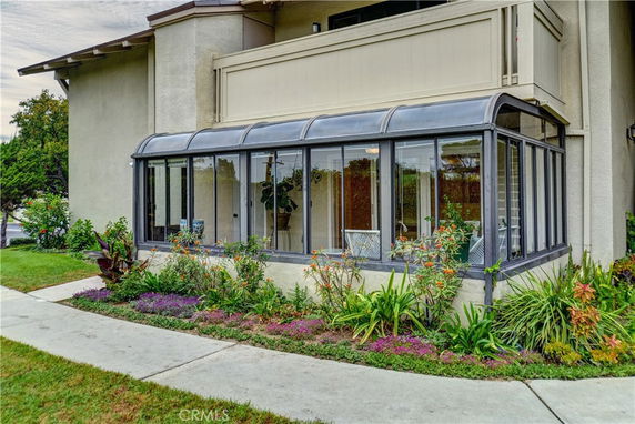 Front view of a house with an enclosed glass sunroom.