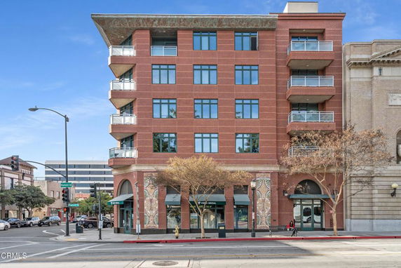 Front view of a multi-story brick building with balconies.