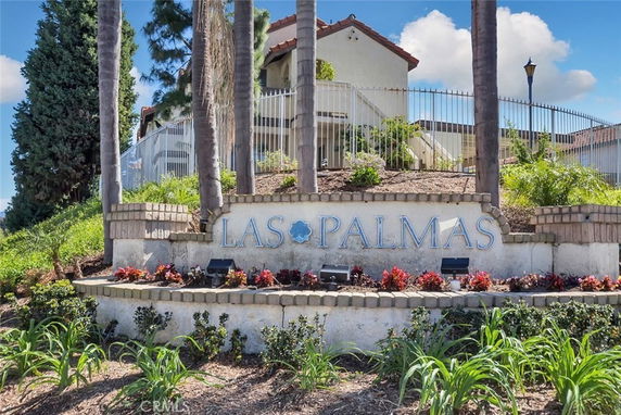 Front view of a building with a sign reading 'Las Palmas' and surrounding landscaping.