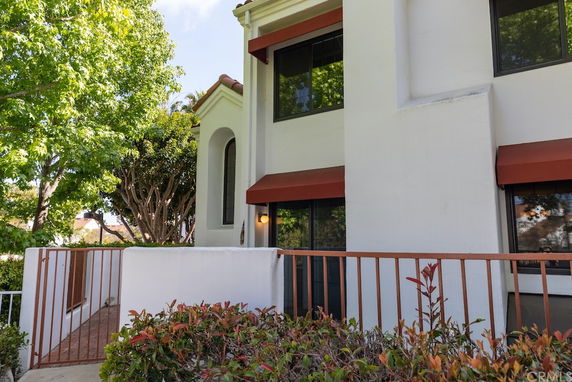 Side view of a two-story building with large windows and red awnings.