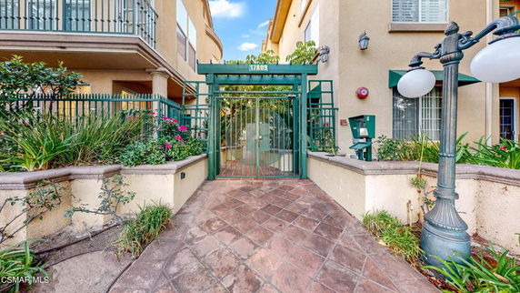 Front entrance view of a multi-story building with gated entry.