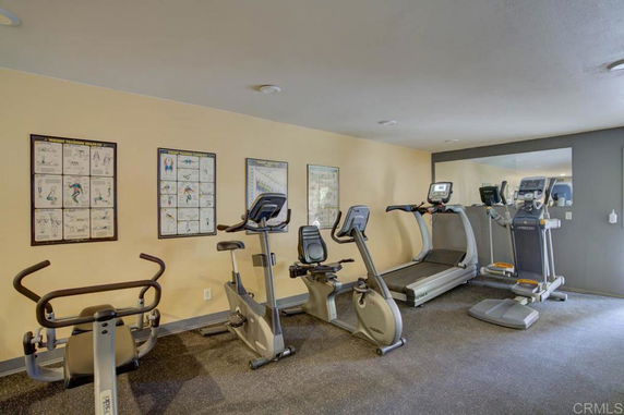 Indoor gym area with exercise equipment and fitness posters.