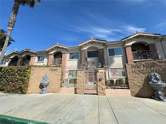 Front view of a two-story residential building with gated entrance.