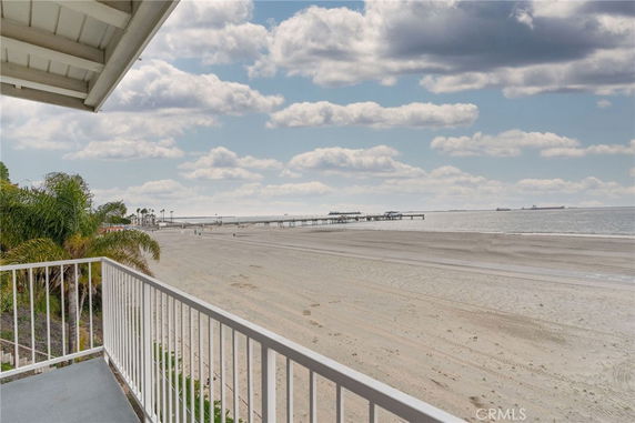 Panoramic view from a building overlooking a sandy beach and ocean.