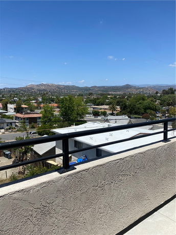 View from a building showing a residential area with mountains in the distance.