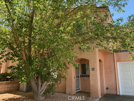 Front view of a two-story house with an arched entrance and attached garage.