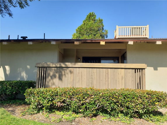 Front view of a single-story house with a small balcony on the roof.
