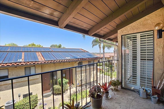 Balcony view of neighboring roofs with solar panels.