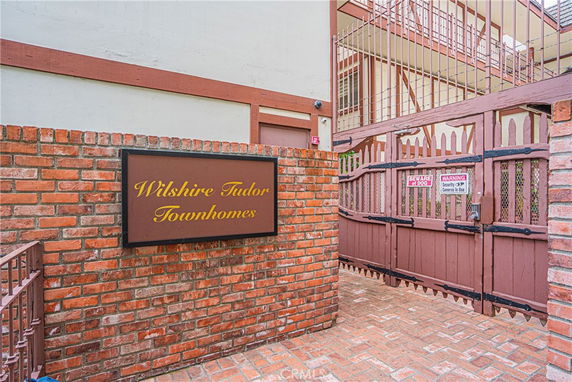 Brick entrance of a residential building with a sign 'Wilshire Tudor Townhomes'.