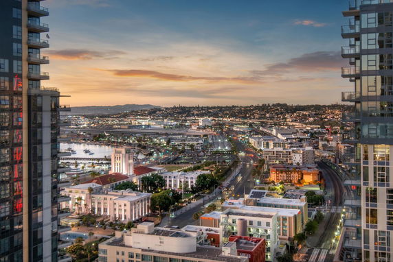 Panoramic view of a cityscape during sunset with buildings and streets.