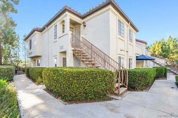 Front view of a two-story residential building with exterior stairs.