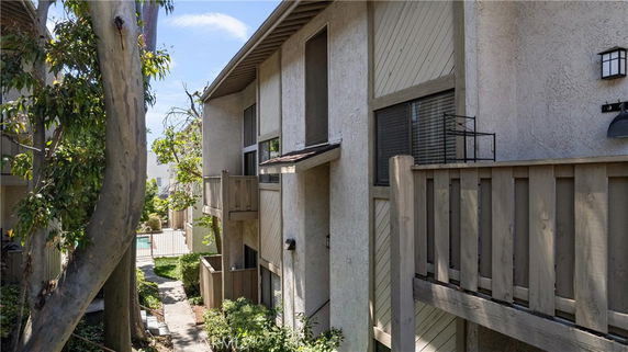 Side view of a multi-story building with balconies and a stucco exterior.