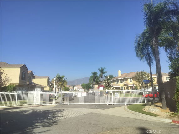 Front view of a gated residential community with multiple two-story houses.