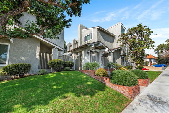 Front view of a multi-story house with a modern design and landscaped front yard.