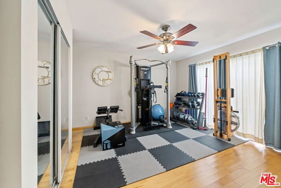 Room with home gym equipment including weights and exercise machines.