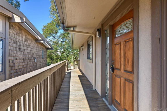 Entrance area with wooden walkway and door of a building.
