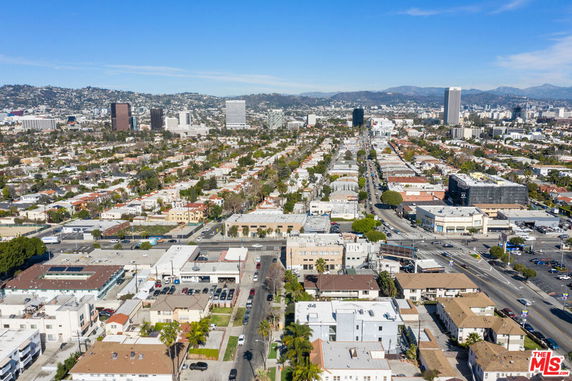 Aerial panoramic view of a cityscape with residential and commercial buildings.
