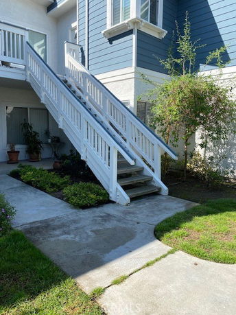 Front view of a building with exterior stairs and blue siding.