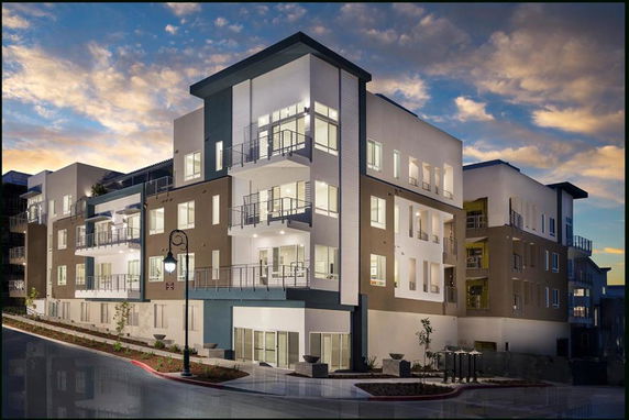 Front view of a modern multi-story apartment building with balconies.