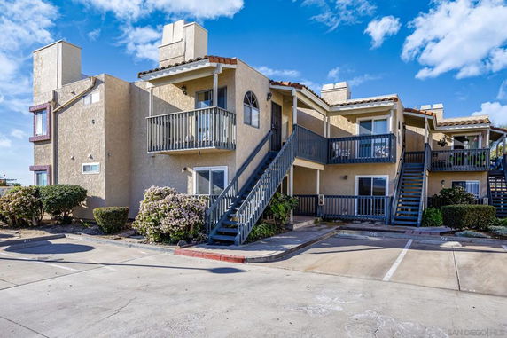 Front view of a two-story residential building with exterior stairs and balconies.