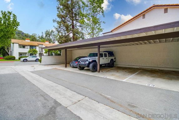 Covered parking area with vehicles parked underneath.