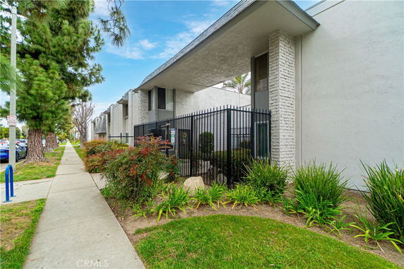 Front view of a building with a fenced entryway and a flat roof design.