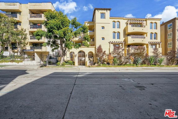 Front view of a multi-story apartment building with balconies.
