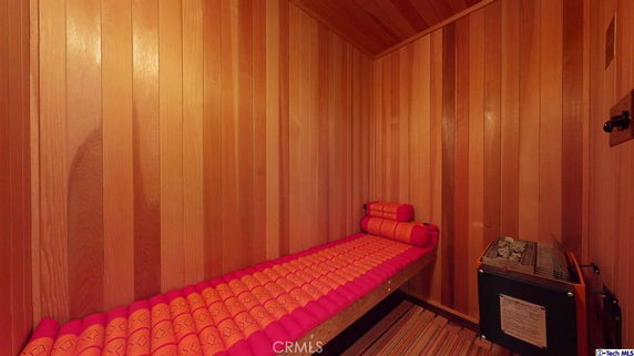 Interior view of a wooden sauna room with a bench and heating unit.