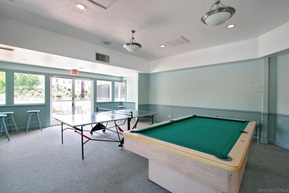 Indoor recreation area with a table tennis setup and a pool table.