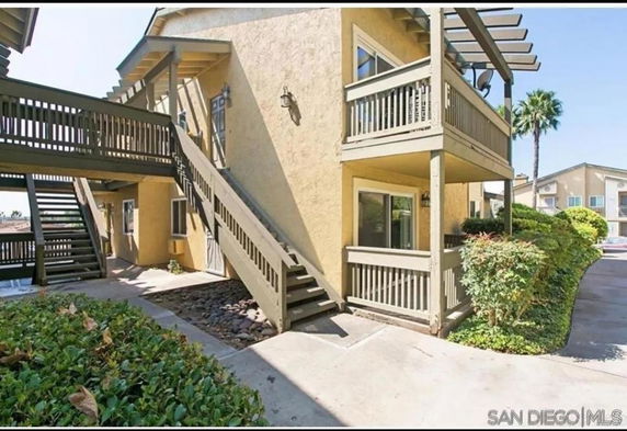 Front view of a multi-story apartment building with outdoor staircases and balconies.