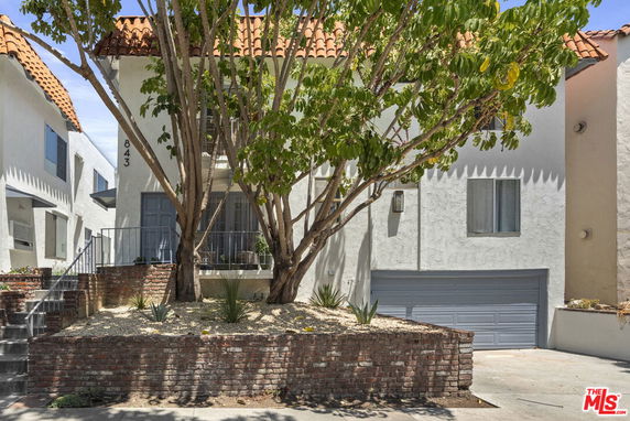 Front view of a two-story house with a garage and tiled roof.