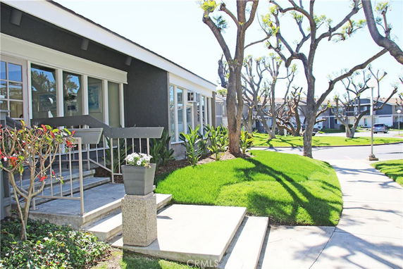 Front view of a single-story house with large windows and landscaped entrance.