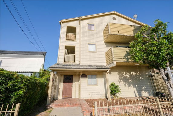 Front view of a three-story residential building with balconies.
