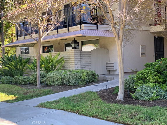 Front view of a two-story building with a small walkway and balcony.