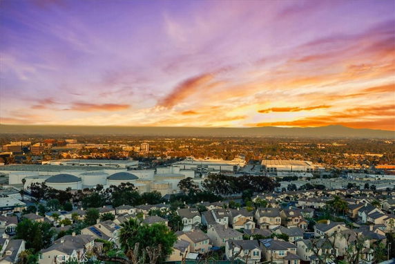 Wide-angle view of a residential and industrial area with colorful sunset.