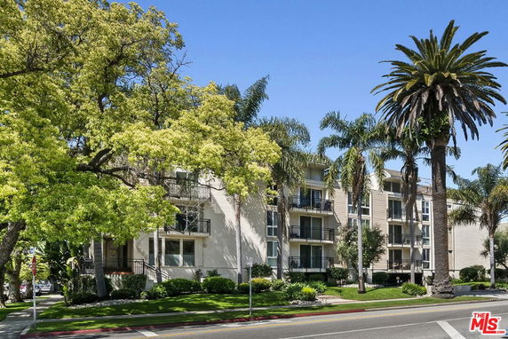 Front view of a multi-story apartment building with balconies.