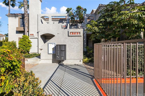 Front view of a multi-story residential building with a gated entrance.