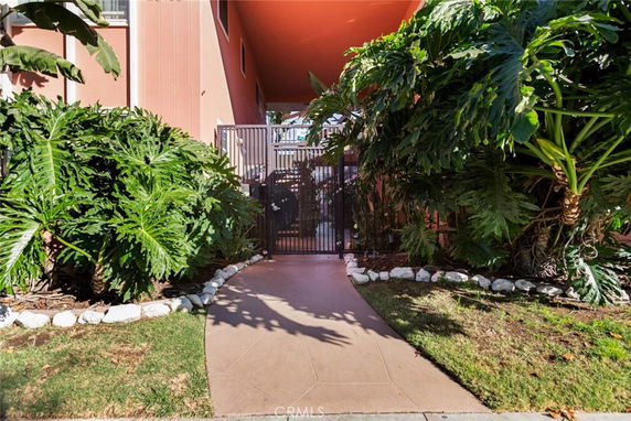 Front view of a building entrance with a gate and surrounding greenery.
