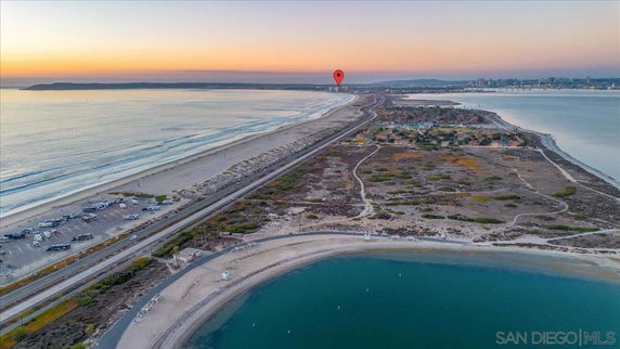 Panoramic view of a coastal area with beaches and ocean at sunset.