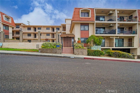 Front view of a multi-story residential building with balconies.