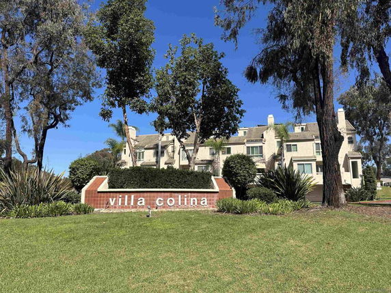 Front view of a multi-story residential building with a landscaped garden.