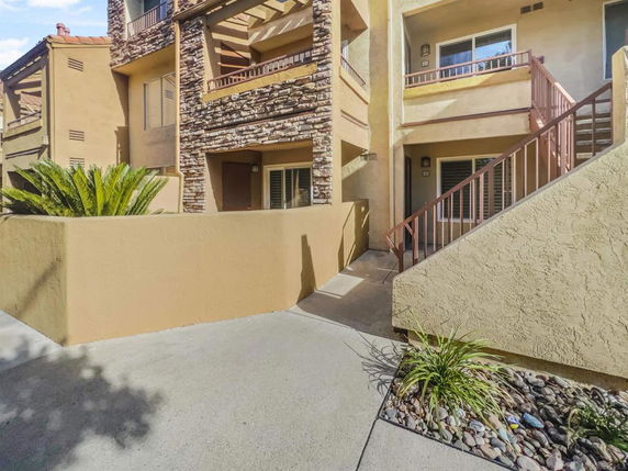 Front view of a multi-story residential building with stone and stucco facade.