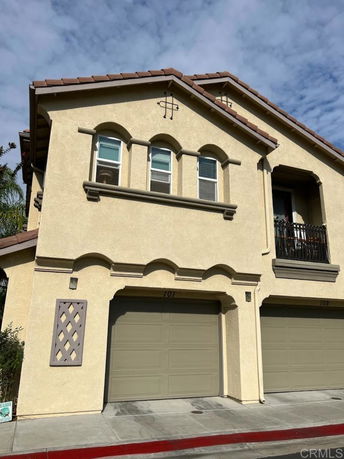 Front view of a two-story house with garage doors and arched windows.