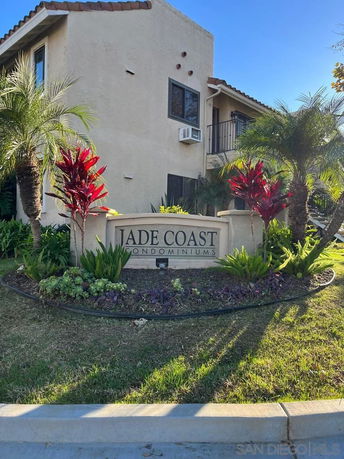 Front view of a condominium building with a sign labeled 'Jade Coast Condominiums'.